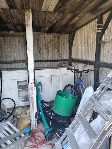 Asbestos cement corrugated sheeting visible on the interior walls of an outbuilding shed