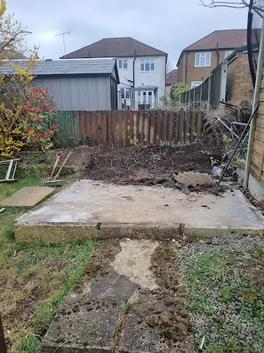 Clean garden area after full asbestos garage removal showing concrete base