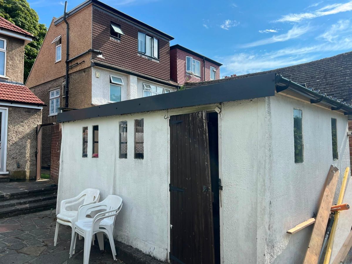 Garage after asbestos roof removal with new black fascia fitted — Croydon